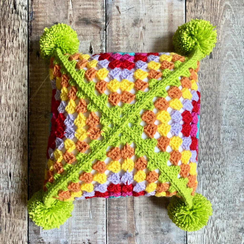 Flatlay of Sideways Granny Throw Pillow on wooden background