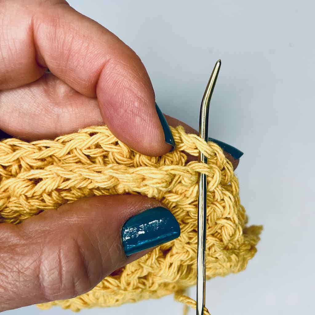 A closeup of sewing the bag motifs together in a ring