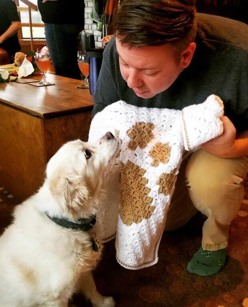 Photo of man holding the puppy love blanket for his dog