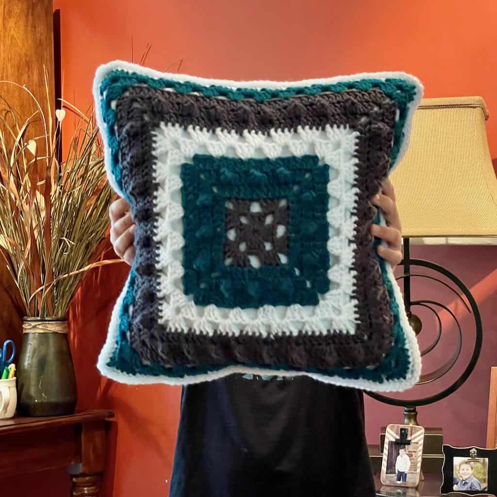 A photo of the granny square side of the football pillow