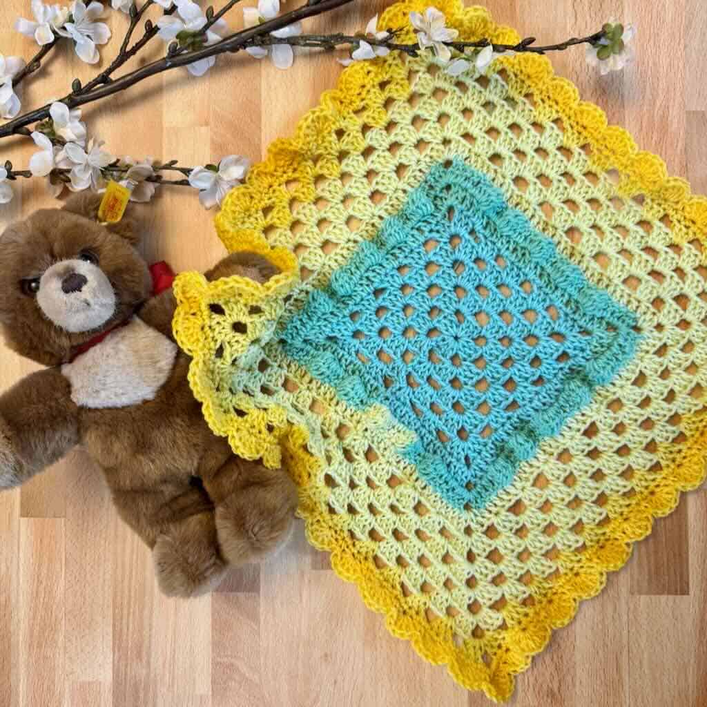 A photo of a preemie lovey with flowers and a bear