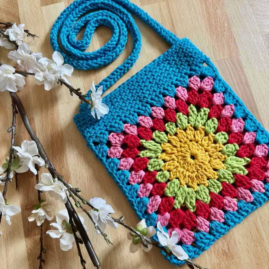 A photo of a granny square crossbody bag with flowers
