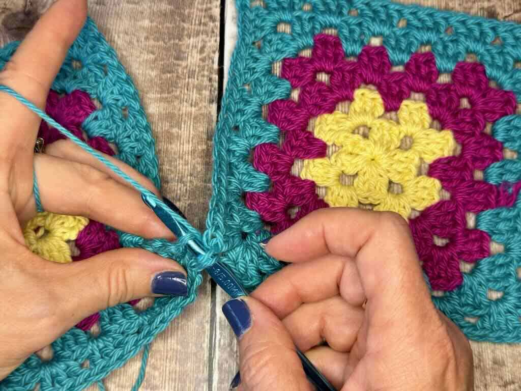 Step 6: Insert hook in the next stitch in the right hand square and in the next stitch of the left hand square; yarn over and pull through all 3 loops.