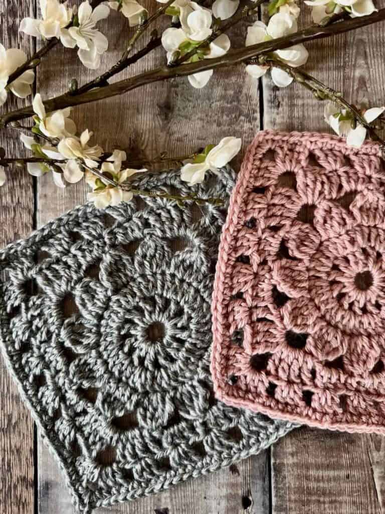 A photo of 2 granny squares on a wood background with flowers