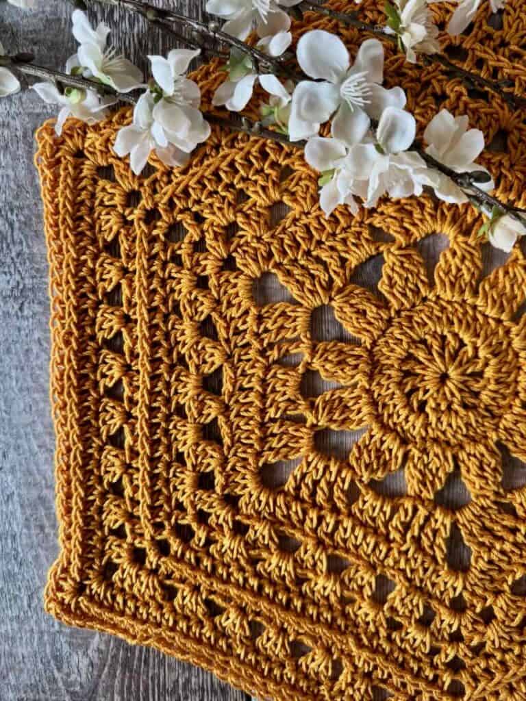 Closeup of the crochet hexagon placemat with flowers on a wooden background