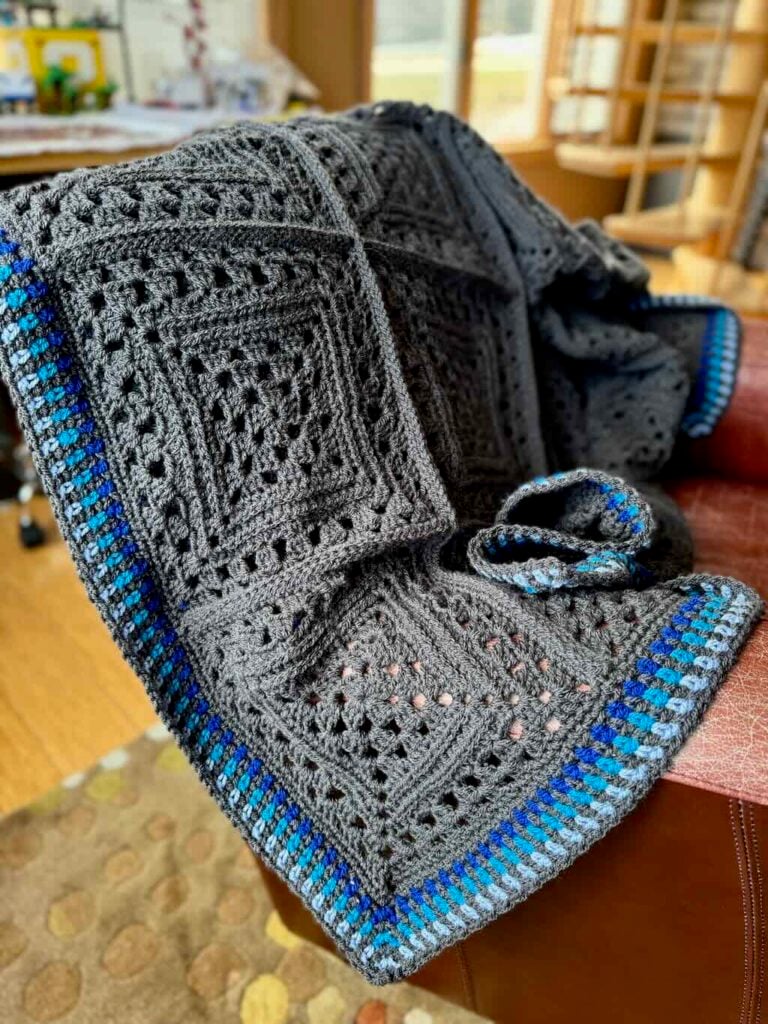 A photo of the Gabe Squared Blanket draped over a chair