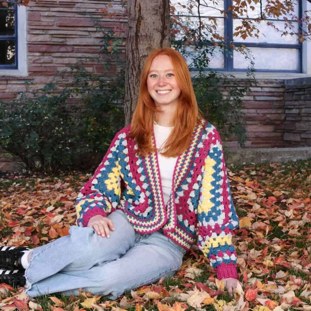A. photo of a college student wearing the Amari Hexagon cardigan