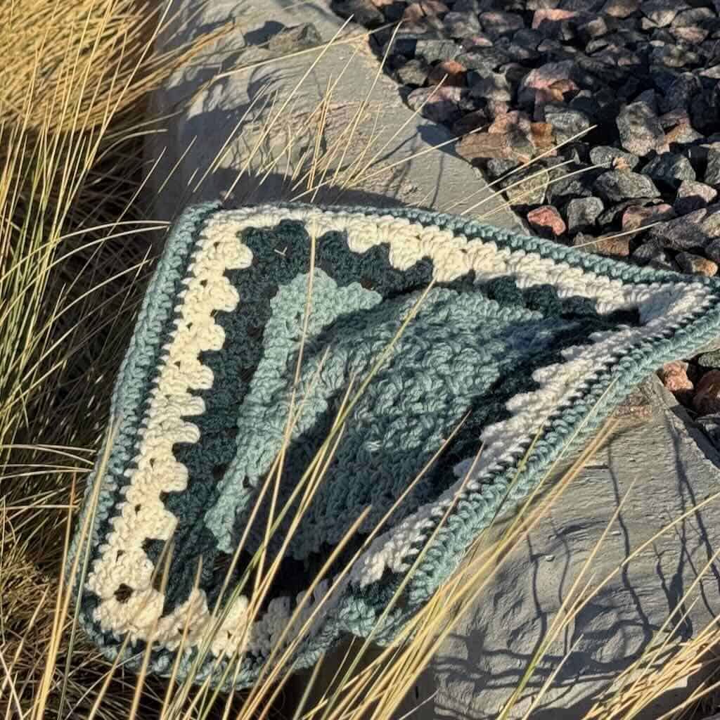 The Tiles granny square posed on rocks